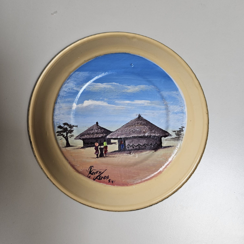 Assiette Kango – Pot traditionnel africain à l’avant, scène de village à l’arrière